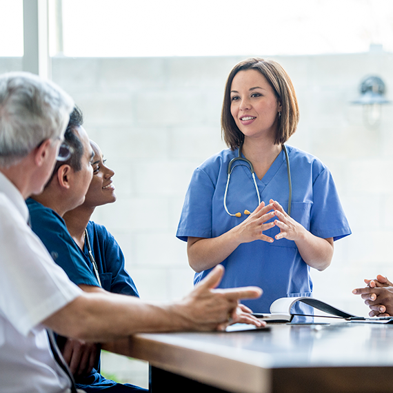 Physician educating group of healthcare professionals in hospital